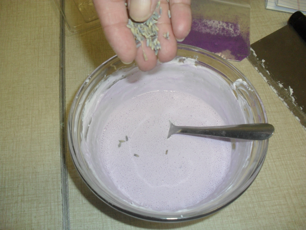 Adding dried lavender to make handmade herbal hand soaps.