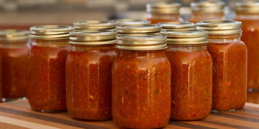 Homemade tomato sauce with oregano in jars.